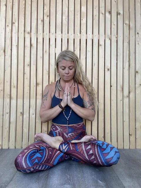 Kvinne med mønstrete tights i yoga-posisjon