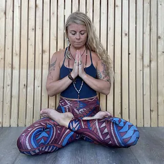 Kvinne med mønstrete tights i yoga-posisjon